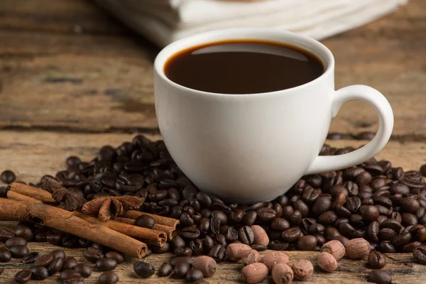 Xícara de café e grão de café em uma mesa de madeira. Fundo escuro . — Fotografia de Stock