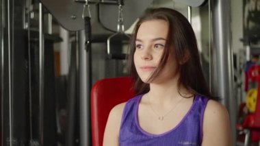 Spor salonunda ya da spor salonunda spor yaparken şişeden su içen fitness kızı..