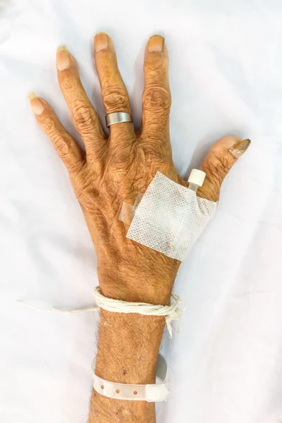 Eski hastane yatağında fiş ile hasta el — Stok fotoğraf
