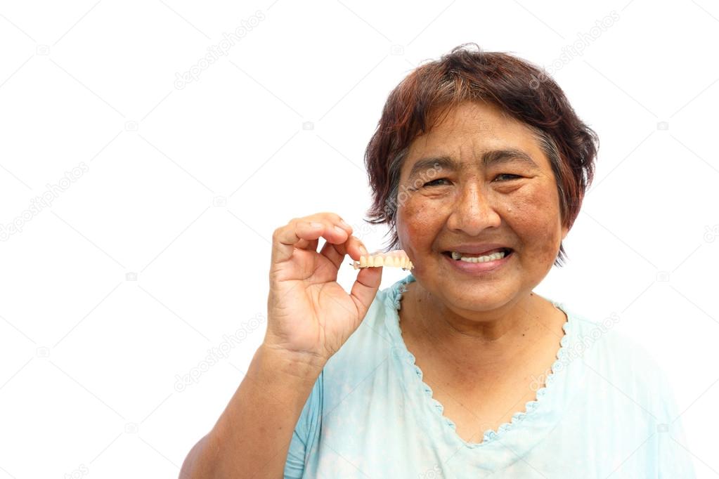Old aged thai woman smile and hold denture. And blank area at le