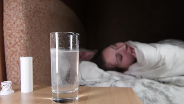 Woman tosses and turns in bed, waiting for the tablet to dissolve in a glass — Stock Video