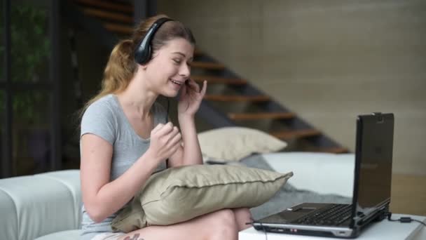 Una mujer joven instala una computadora de trabajo para trabajar desde casa. Trabajo remoto — Vídeo de stock