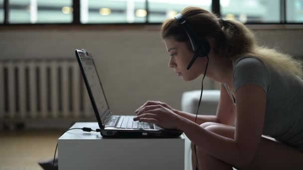 Una giovane donna che lavora a distanza è molto stanca e cade a faccia in giù in un computer portatile — Video Stock