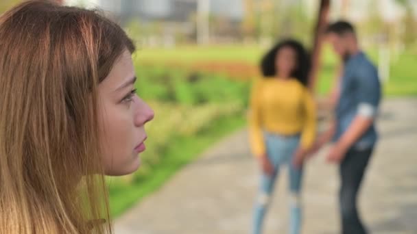 Young woman is sad. out of focus man and a black woman communicate very closely — Stock Video