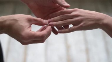 Bir adam bir kadına evlenme teklif eder ve parmağına yüzük takar.