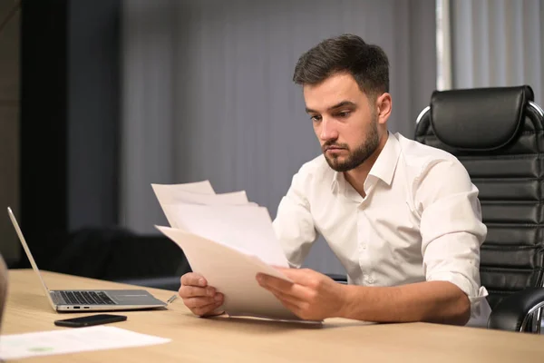 Joven Jefe Empresa Examina Los Informes Impresos Papel Está Perplejo — Foto de Stock