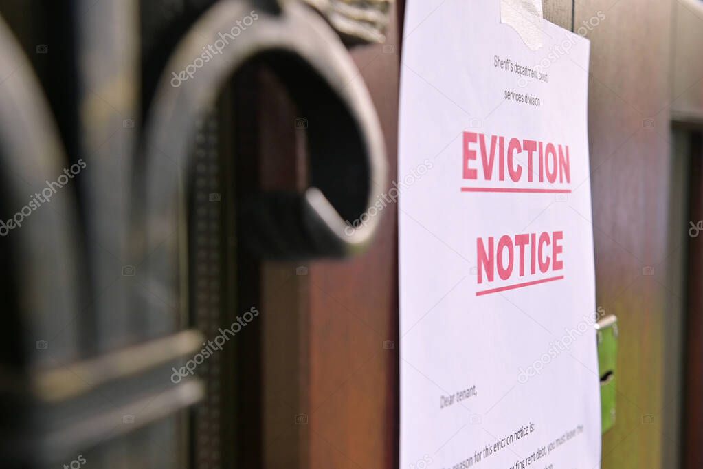 the notice of eviction of tenants hangs on the door of the house, front view