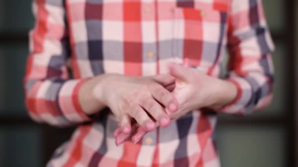 Meisje wrijft hand crème in haar vingers — Stockvideo