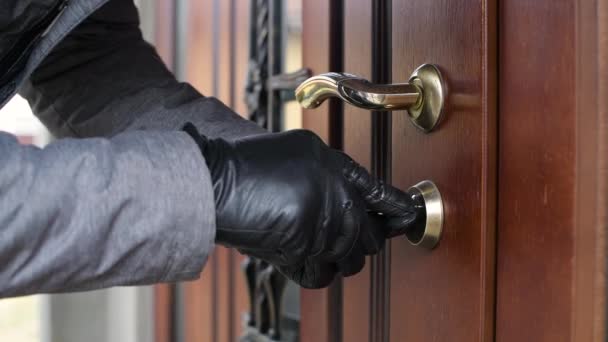 Ένας κλέφτης με γάντια ανοίγει την πόρτα ενός ιδιωτικού σπιτιού και εισχωρεί μέσα. — Αρχείο Βίντεο