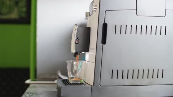 Koffiezetapparaat schenkt espresso in een transparante kop — Stockvideo