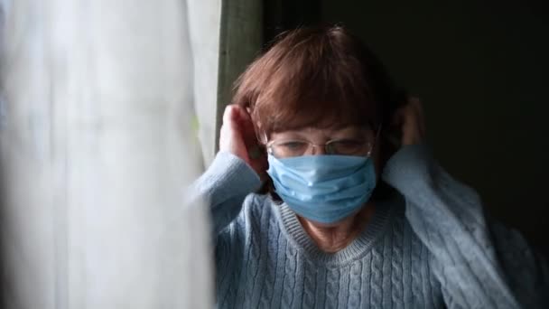 Vrouw zet op een medisch masker dan verwijdert het masker en zucht met verlichting — Stockvideo