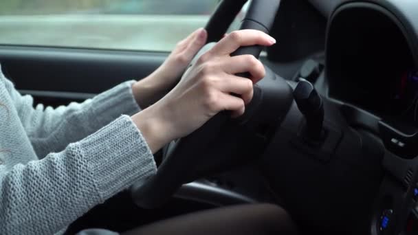 Tangan seorang wanita muda memegang kemudi mobil saat mengemudi, tidak ada wajah — Stok Video