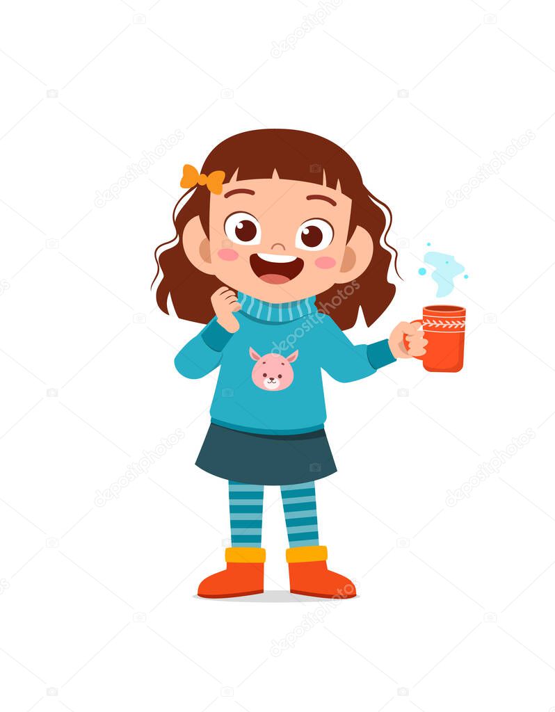 happy cute little kid drink hot chocolate in winter season. child drink milk wearing warm clothes