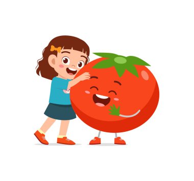 Sevimli küçük kız domates karakteriyle duruyor.