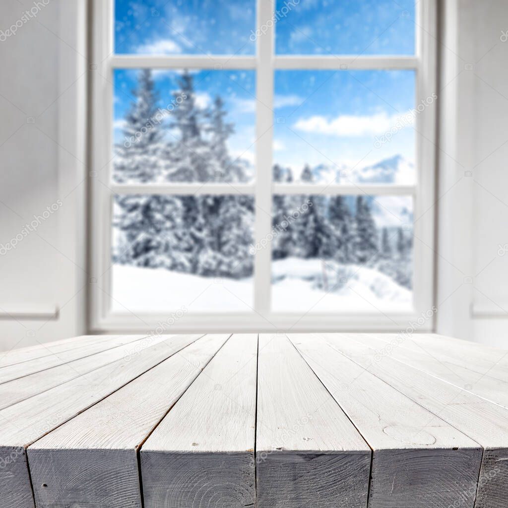 White winter window view with a wooden table and a place for an advertising product.