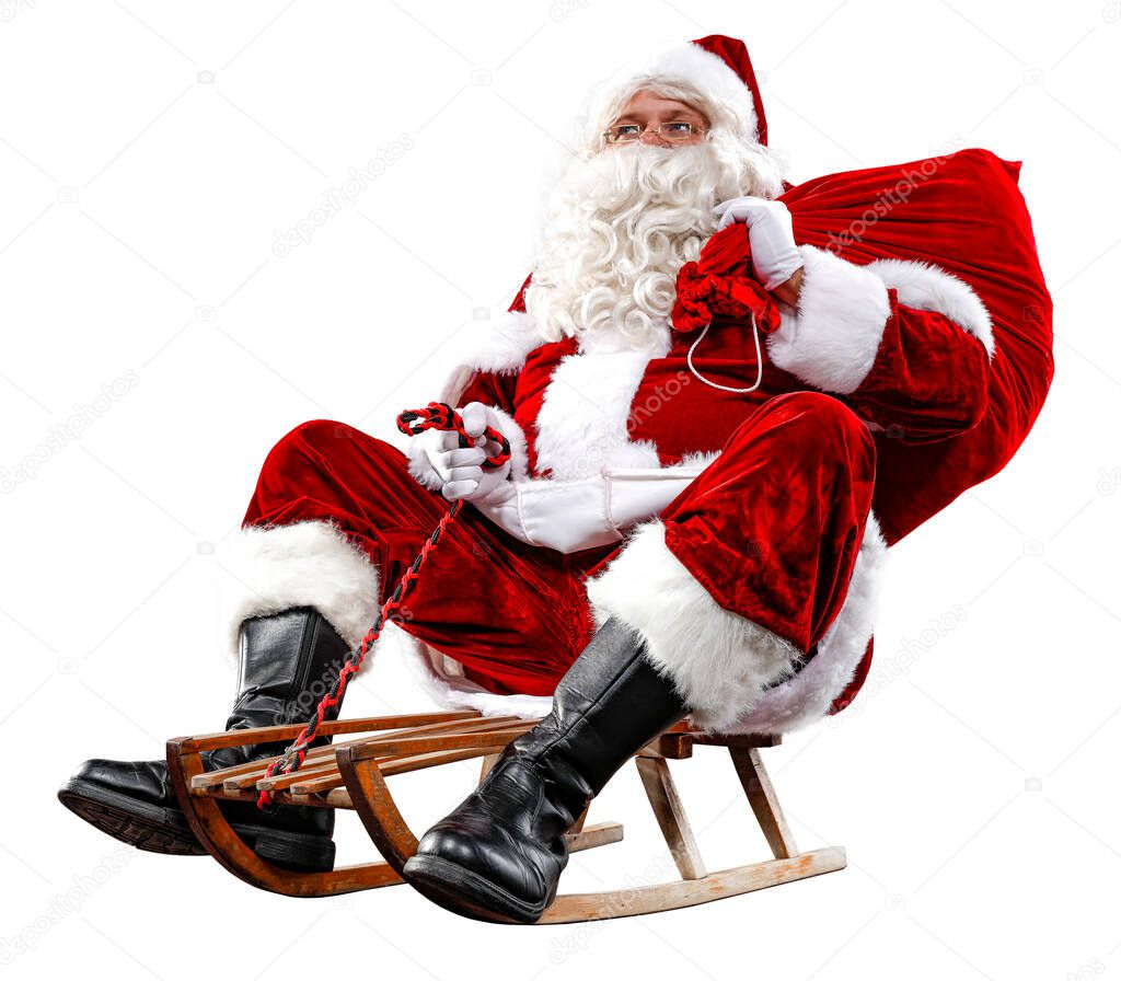 Santa Claus on his sleigh with a sack with presents. Winter snowy day with white snow background. Winter and Christmas time. Red Santa Claus riding a wooden sled. An older man with a beard delivers presents to a child.