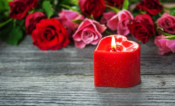 Rose e una candela — Foto Stock