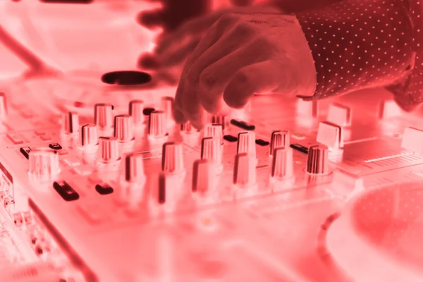 DJ mischt den Track in einem Nachtclub auf einer Party mit tanzenden Menschen auf verschwommenem Hintergrund — Stockfoto