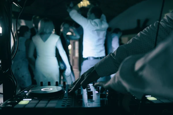 Dj mescola il brano in discoteca alla festa con persone che ballano su sfondo sfocato — Foto Stock