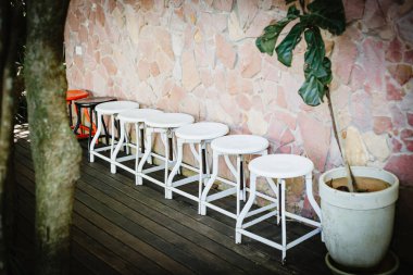 Beyaz sandalyeler ahşap bir zeminde dizilmişti..