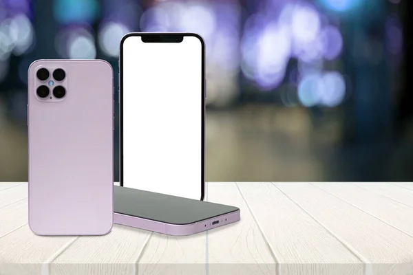 Beyaz ahşap masada üç akıllı telefon. Beyaz beyaz ekran.