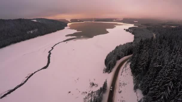 Luchtfoto beeldmateriaal van bevroren winter meer bij zonsondergang — Stockvideo