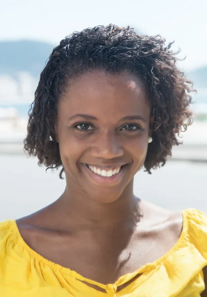 Retrato de una mujer afroamericana con camisa amarilla — Foto de Stock