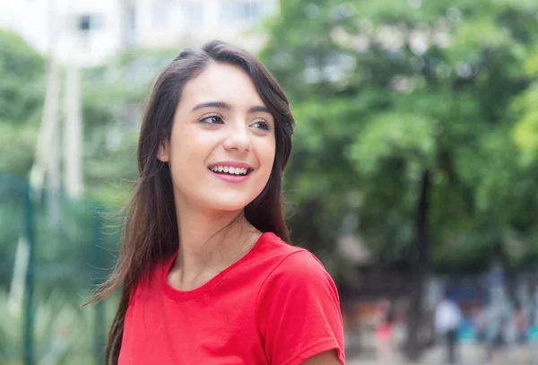 Donna attraente in una camicia rossa all'aperto in un parco — Foto Stock