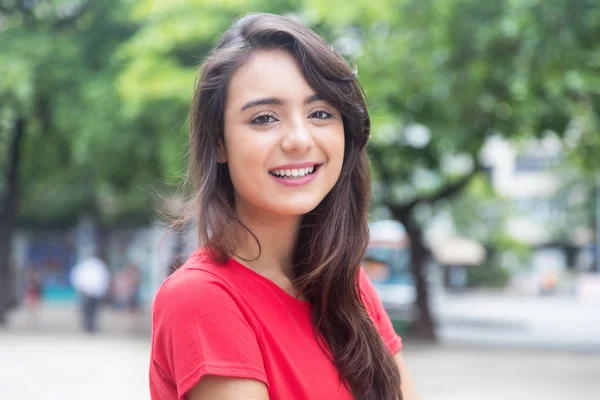 Mulher rindo em uma camisa vermelha ao ar livre em um parque — Fotografia de Stock