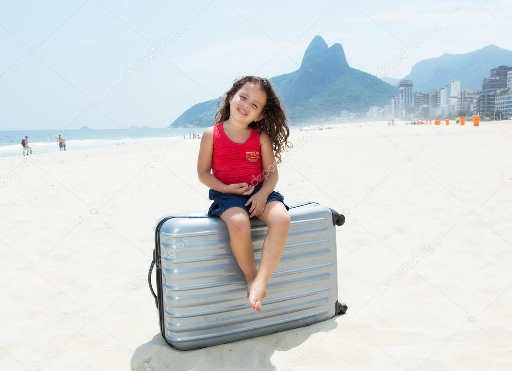 Child with suitcase at Copacabana beach at Rio de Janeiro