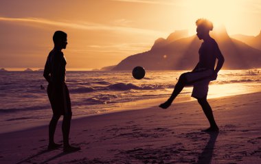 İki adam, Rio de Janeiro kumsalda oynarken futbol