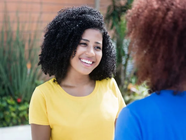 Mujer latina con el pelo negro rizado hablando con su novia — Foto de Stock