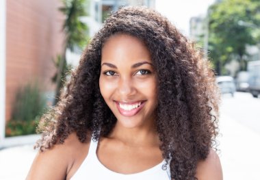 Şehrin kıvırcık saçlı Karayip kadın gülüyor