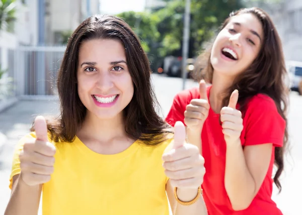 親指に現れる 2 つの幸せな白人女性 — ストック写真