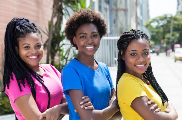 Drei lachende afrikanisch-amerikanische Freundinnen in der Schlange in der Stadt — Stockfoto