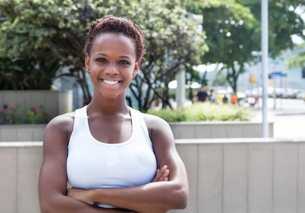 Africano menina americana com cabelo curto e braços cruzados na cidade — Fotografia de Stock