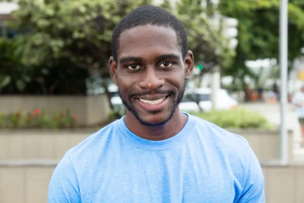 Uomo africano ridente con barba e camicia blu — Foto Stock