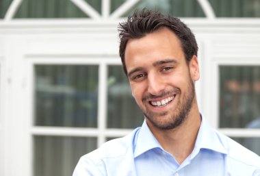 Açık havada gülümseyen Latin iş adamı