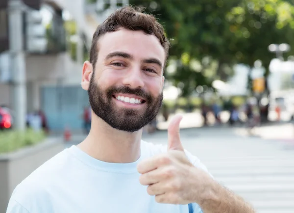 Homem caucasiano com barba mostrando polegar ao ar livre na cidade — Fotografia de Stock