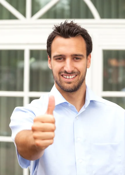 Sorrindo latino homem de negócios mostra seu polegar — Fotografia de Stock