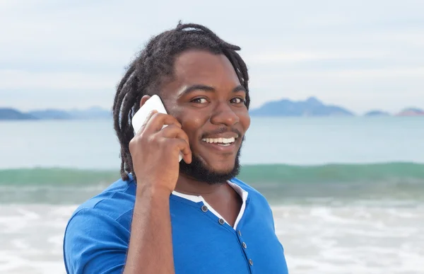 Divertido afroamericano chico con rastas en el teléfono — Foto de Stock