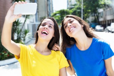 Selfie ile cep telefonu alarak iki beyaz kız