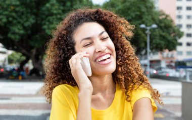 Meksikalı kız telefon açık şehirde gülüyor