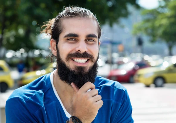 Счастливый человек с бородой и голубой рубашкой в городе — стоковое фото