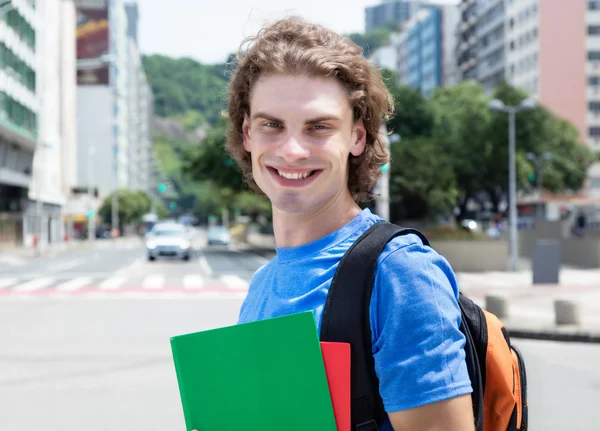 Skrattande kaukasiska manlig student i staden — Stockfoto