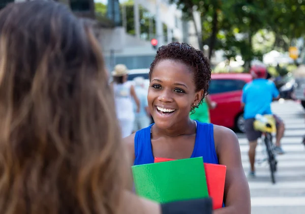 Afro-Amerikaanse vrouwelijke student voldoet aan een Kaukasische vriendin — Stockfoto