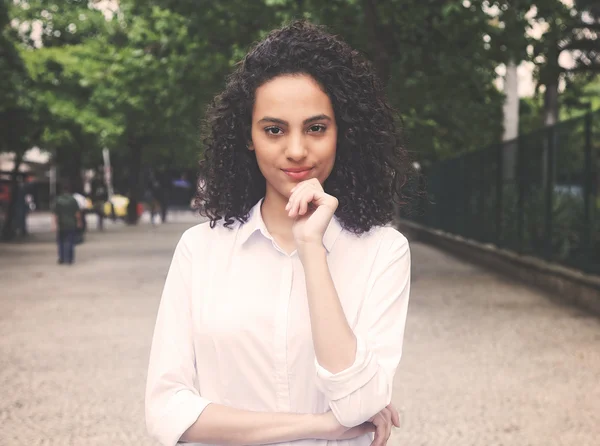 Smiling caribbean woman in a park in vintage warm cinema look — Stock Photo, Image