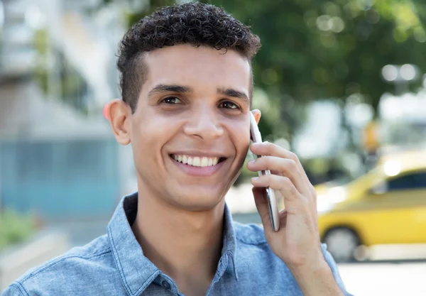 Rindo latino homem no telefone na cidade — Fotografia de Stock