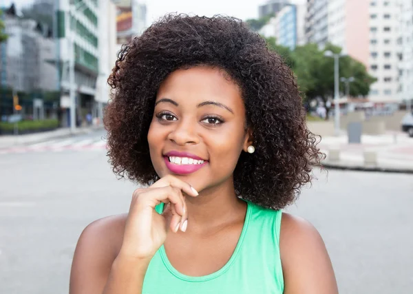 Mujer moderna de África en una camisa verde en la ciudad — Foto de Stock