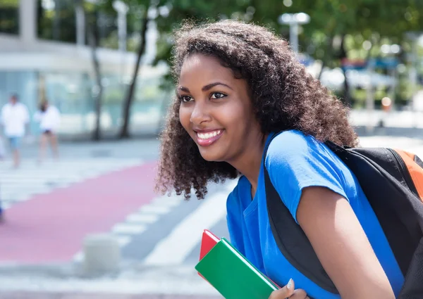 Glücklich lateinische Studentin mit lockigem Haar — Stockfoto